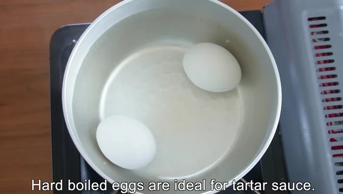 Hard-boil the eggs, separate the yolks and whites. Mix the yolks with mayonnaise. Chop the egg whites finely and mix them into the tartar sauce.