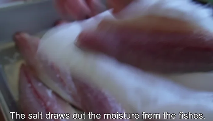 After 15 minutes, wipe off any excess moisture from the salted fish fillets.