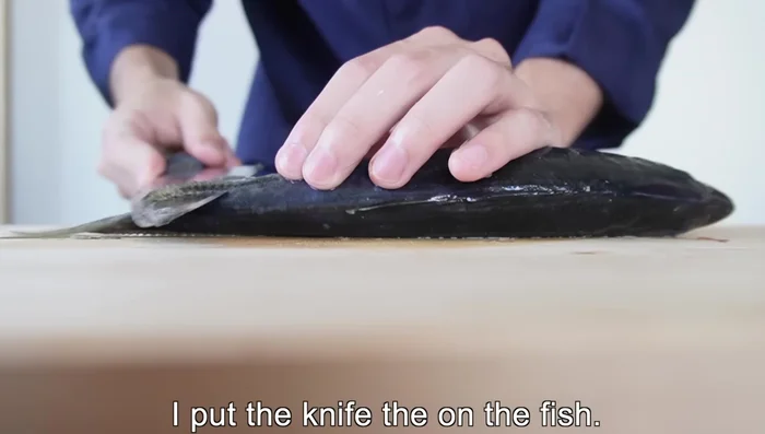 Remove the scales and clean the horse mackerel carefully. Use the entire length of the knife, adjusting your grip for different parts of the fish.