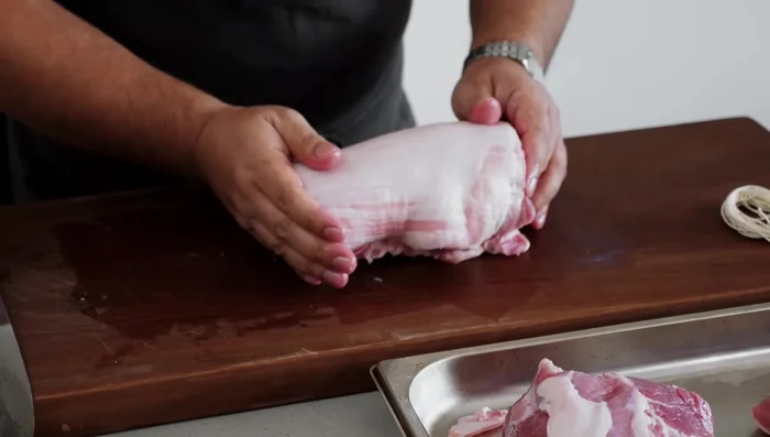 Roll the pork belly: Starting from the thin end, tightly roll the pork belly. Secure with butcher's twine using a double shoelace knot.