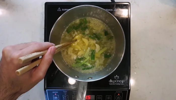 Render chicken fat from chicken skin with green onions, garlic, and ginger. Cool and store.