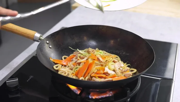 Return the stir-fried vegetables and chicken to the wok.