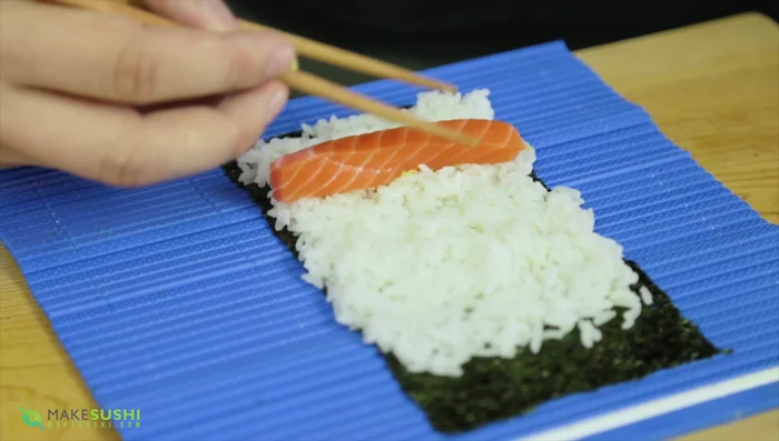 Add wasabi, salmon, asparagus, carrot, radish, tobiko, and avocado to the rice.