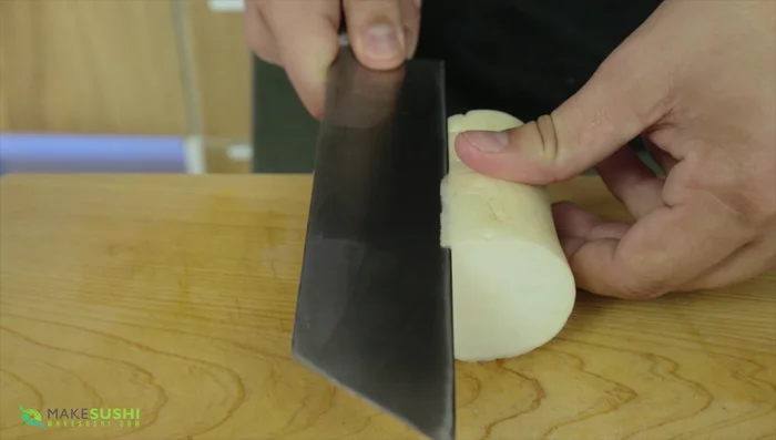 Prepare the daikon radish by cutting it into a thin sheet using the capsular mookie technique (a video link is provided in the original video description).