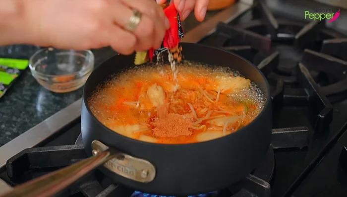 Add both soup packets and dehydrated vegetables from the ramen. Mix.