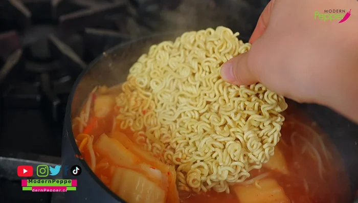 Add the ramen noodles (without breaking them) and any residue from the packaging.