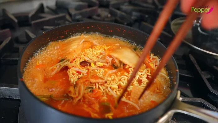 Increase heat to high, push kimchi to the top, and cook for 1.5 minutes, shaking occasionally to prevent overcooking.