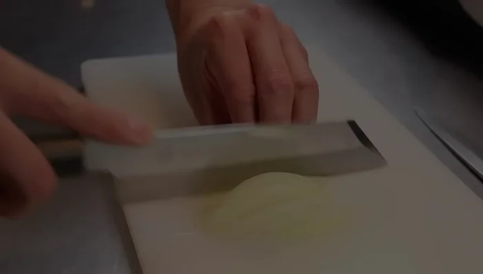 Cut a white onion into 3mm slices. Cut a spring onion diagonally into thin slices.