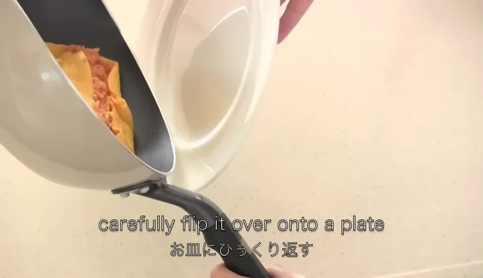 Flip the omelet onto a plate. Use a paper towel to lightly shape it and remove excess oil.