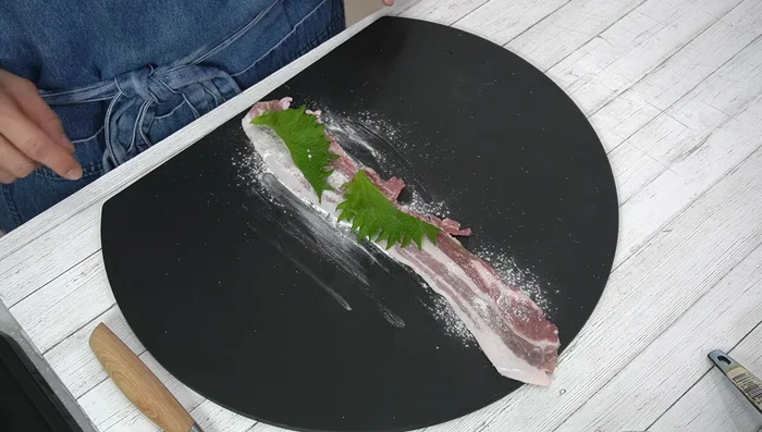 Place a shiso leaf on each pork belly slice and roll tightly.