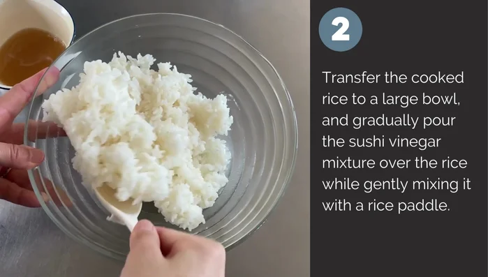 Transfer cooked rice to a large bowl and gradually pour sushi vinegar, gently mixing with a rice paddle.