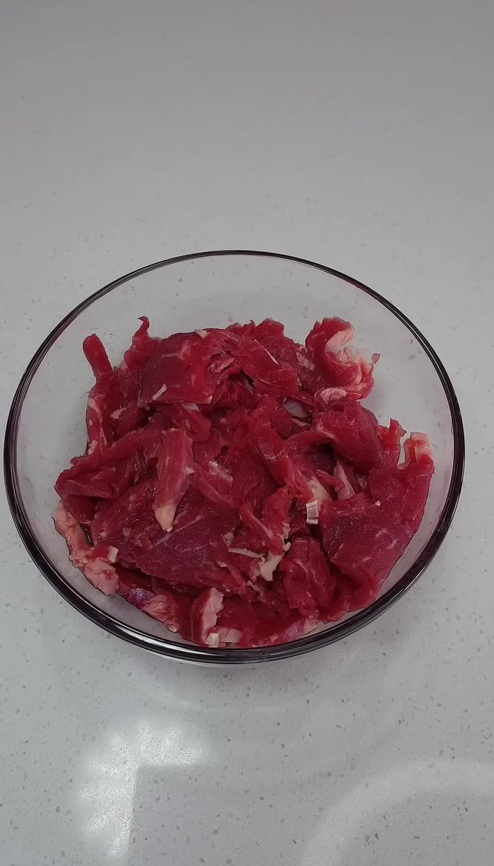 Marinate thinly sliced ribeye steak in a mixture of teriyaki sauce, baking soda, cornstarch, garlic powder, onion powder, and black pepper. Set aside for 15-20 minutes. (Start: 10.88)