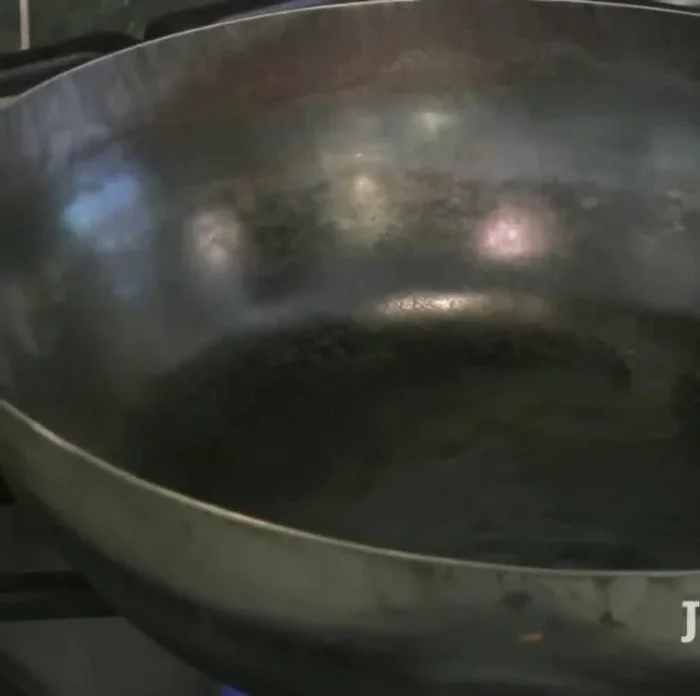 Heat up a wok or large skillet and add oil, minced ginger, and garlic.