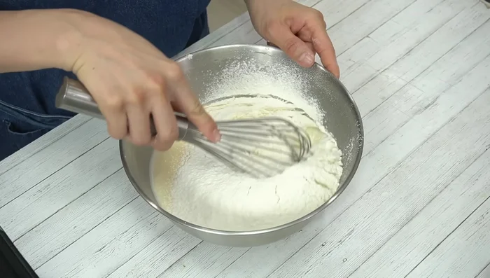 Sift in cake flour and mix carefully. Strain the batter to remove lumps.