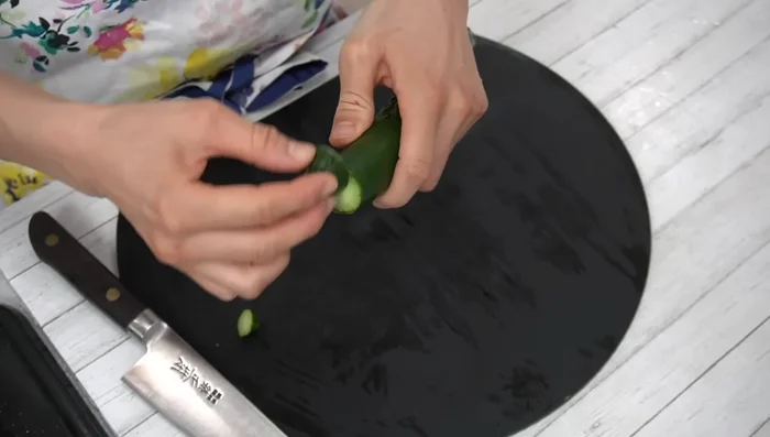 Cut off both ends of the cucumber. Line up the cut ends and rub them together to remove imperfections.
