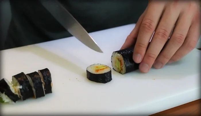 Cut the sushi roll in half, then into quarters, and finally into eights (or more, depending on preference). Aim for thin, even slices.