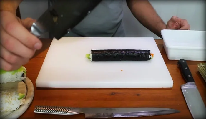 Dip your knife in water before each cut. A bead of water running down the blade prevents sticking and helps the knife glide smoothly through the sushi.