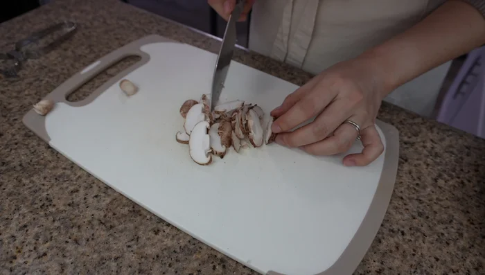 Prepare ingredients: Thinly slice shiitake mushrooms. Chop mitsuba herbs for garnish. Slice kamaboko thinly. Cut chicken into bite-sized pieces.