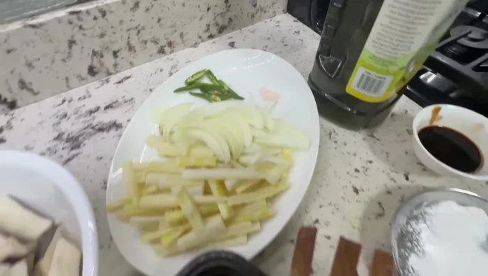 Prepare the other vegetables: finely chop the white onions and green chilies.