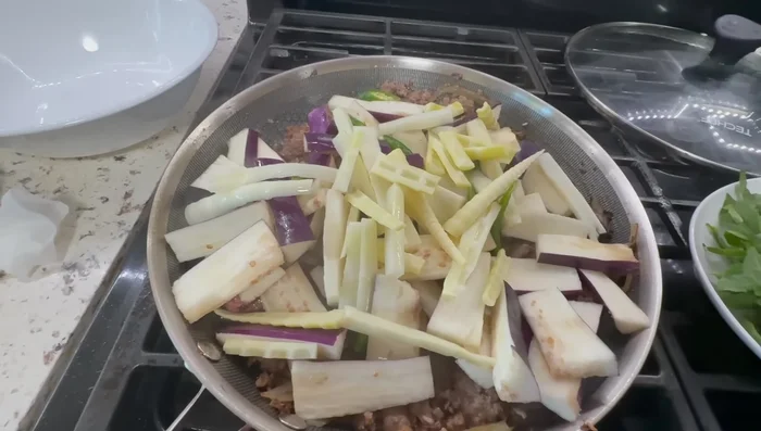 Add the green chilies and sliced bamboo shoots, stir-fry and cover the pan to cook for 3 minutes.