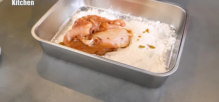 Deep fry the chicken: Deep fry the chicken in hot oil, pressing it down to ensure the batter sticks and becomes crispy. Flip and continue frying, adjusting the position to prevent burning.