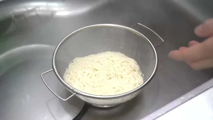 Immediately drain the noodles and rinse thoroughly with cold water to remove excess starch and prevent sticking.