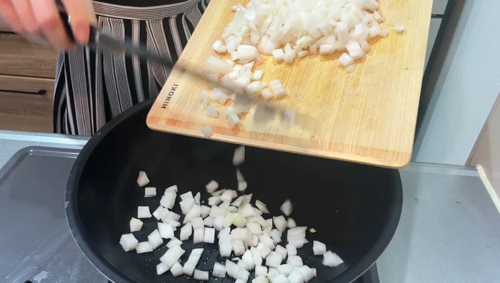 Add oil to a pan and fry the onion and eggplant until onions are translucent.