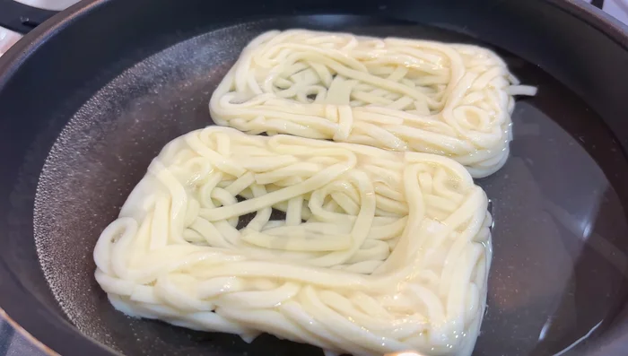 Cook udon noodles according to package instructions. Rinse to remove excess starch if using dried udon.