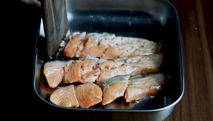Break the warm salmon flesh into bite-sized pieces, carefully removing any bones.