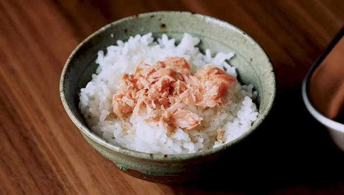 Arrange salmon flakes and crispy skin on top of the rice. Add green onions.