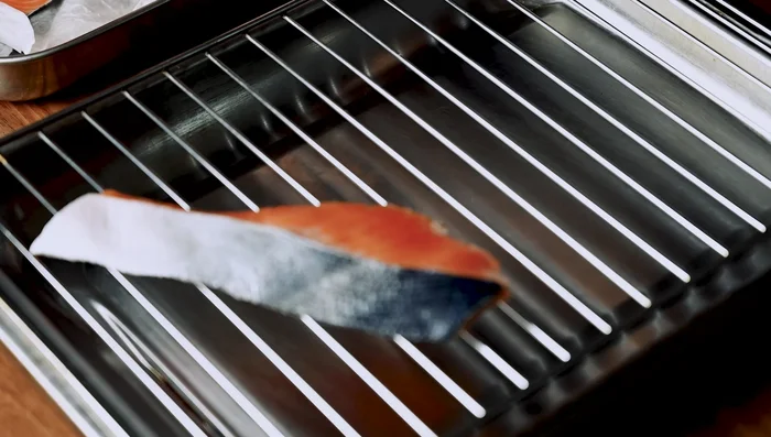 Grill the salmon skin-side down until the skin is blistered and crispy. Flip and cook until done. Check for doneness by looking for a color change from translucent deep pink to opaque light pink with white protein dots.