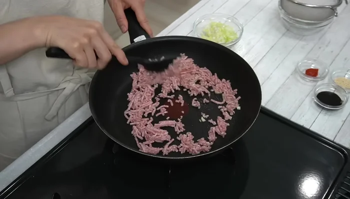 Add minced meat and stir-fry until about half-cooked. Add green onions and continue to stir-fry.