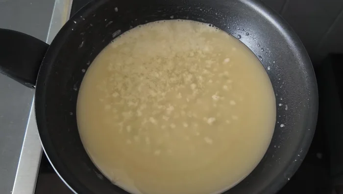 Once the oil is hot and the flour mixture begins to sizzle, add the marinated chicken pieces, ensuring they don't overlap.